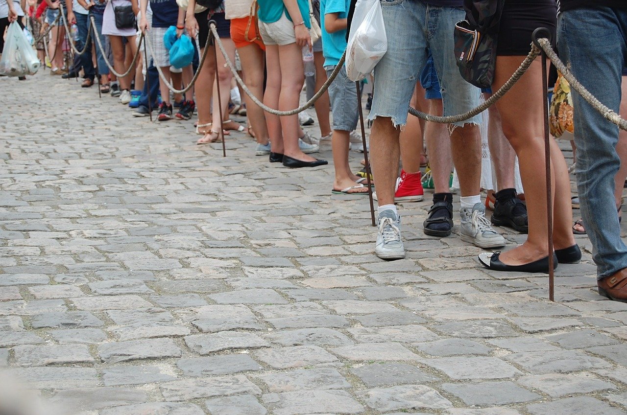 Imagem mostra pessoas em uma fila de espera. Agora, os fura-filas da vacina serão multados