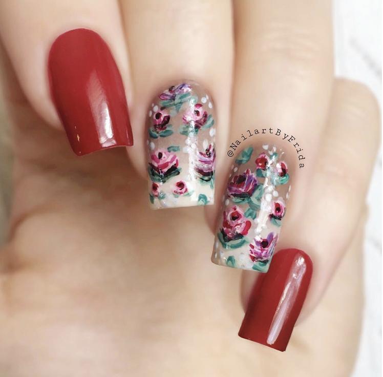 Unhas da mão com flores vermelhas delicadas