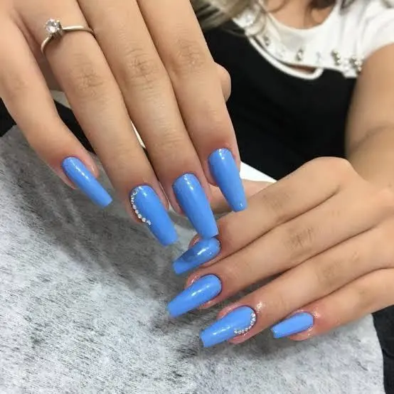 Unhas longas e quadradas com esmalte azul claro