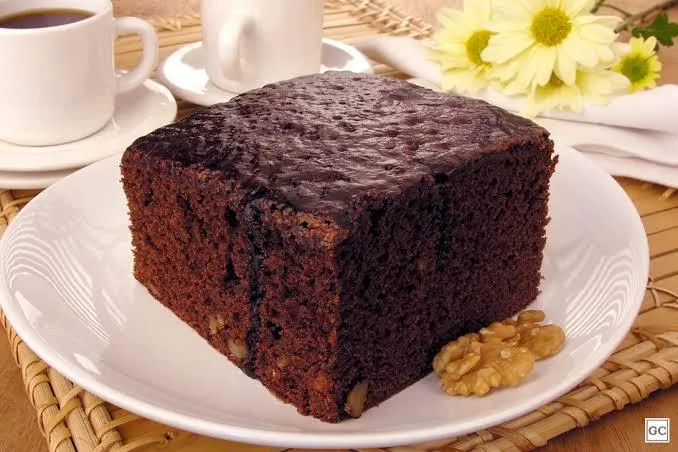 Um pedaço quadrado de bolo de chocolate tipo brownie, em um prato branco