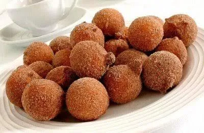 Bolinhos de chuva morenos em cima de uma travessa branca