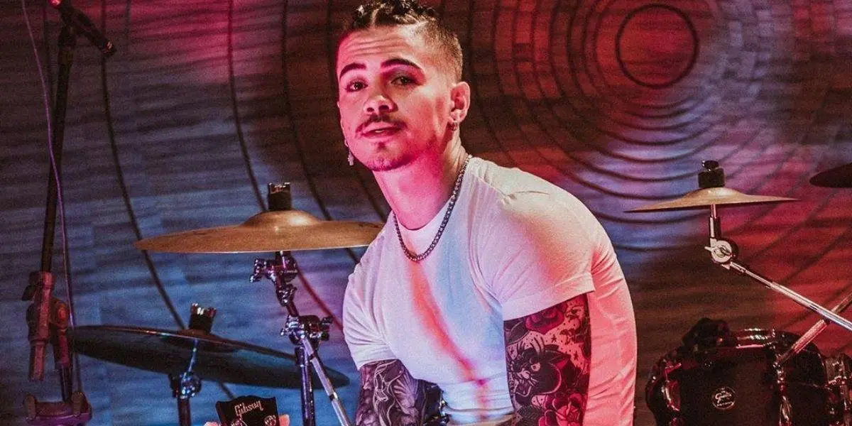 Cantor Biel sentado em uma bateria olhando para frente - A fazenda 2020