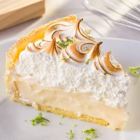 Um pedaço triangular de torta de limão com a cobertura dourada - receitas de torta de limão