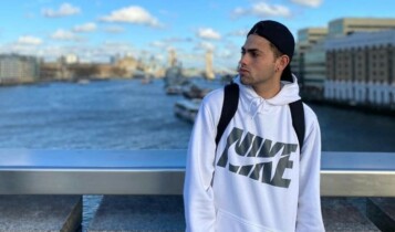 Mario Junior encostado em uma ponte com o mar de fundo