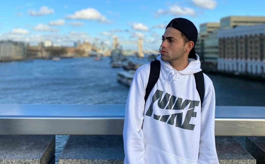Mario Junior encostado em uma ponte com o mar de fundo