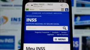 Foto de um celular com a página do INSS aberta
