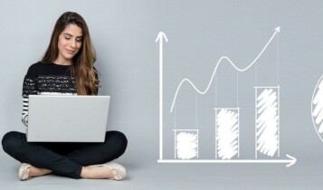 Mulher usando o notebook; ao lado dela aparecem gráficos