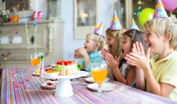 crianças em festa de aniverário cantando parabéns de forma bem alegra