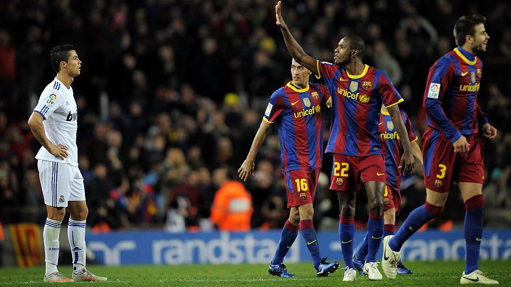 Imagem mostra eric Abidal comemorando gol do barcelona com Cristiano Ronaldo de fundo