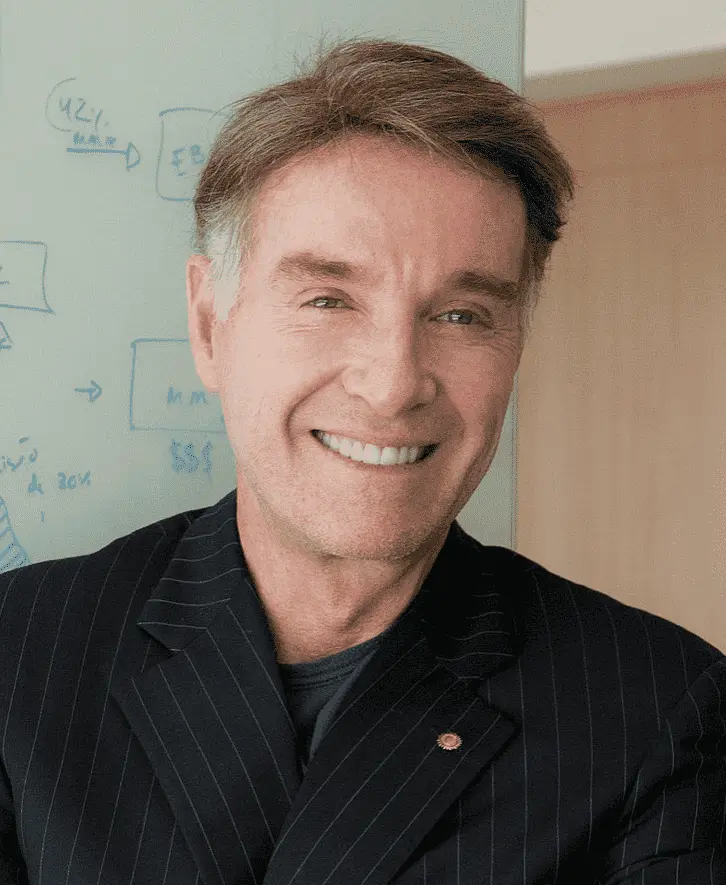 Foto do ex-milionário Eike Batista, sorrindo e vestindo um terno preto.