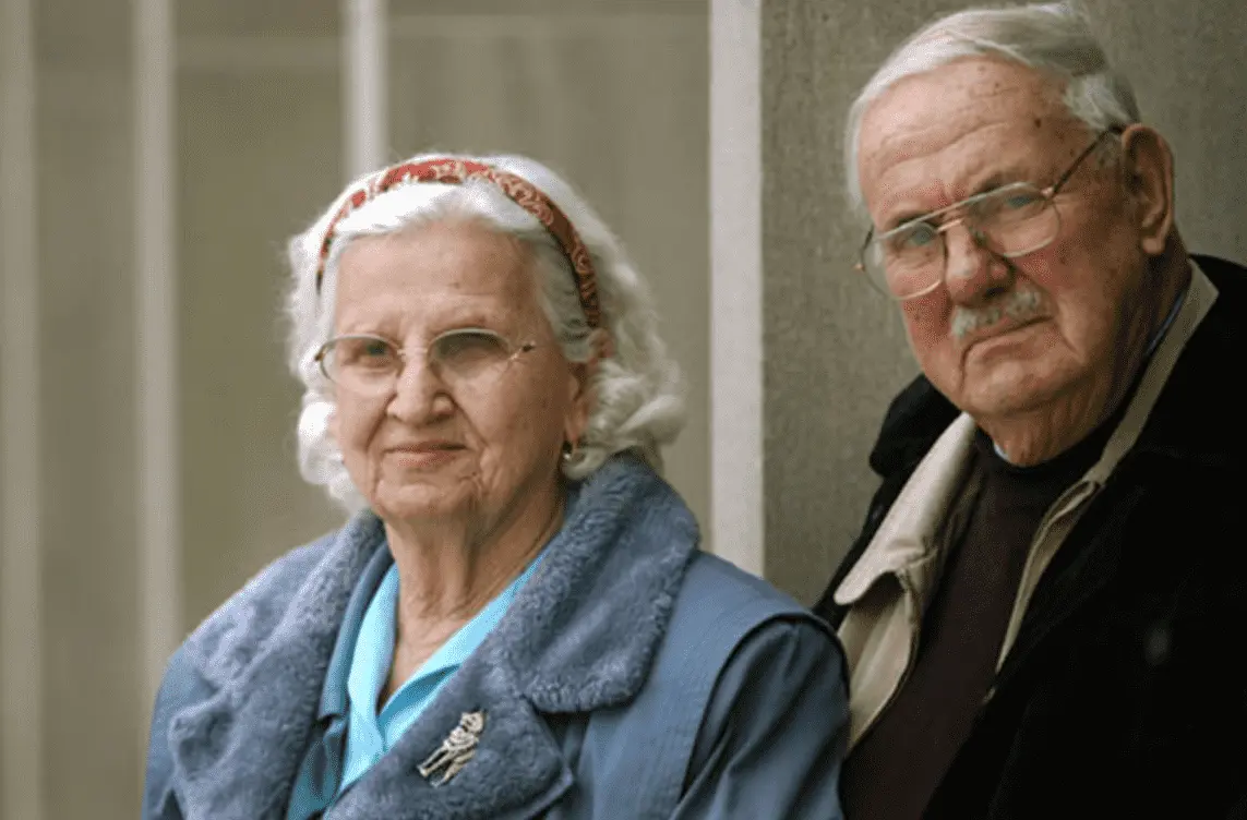 Imagem mostra Alex e Rhoda Toth, casal de idosos. Ambos tem cabelos brancos, e vestem casacos. O homem usa óculos e bigode.