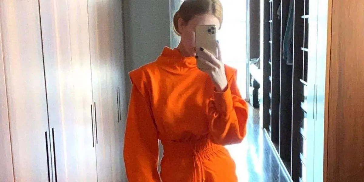 Marina Ruy Barbosa de roupa laranja tirando foto de frente para o espelho
