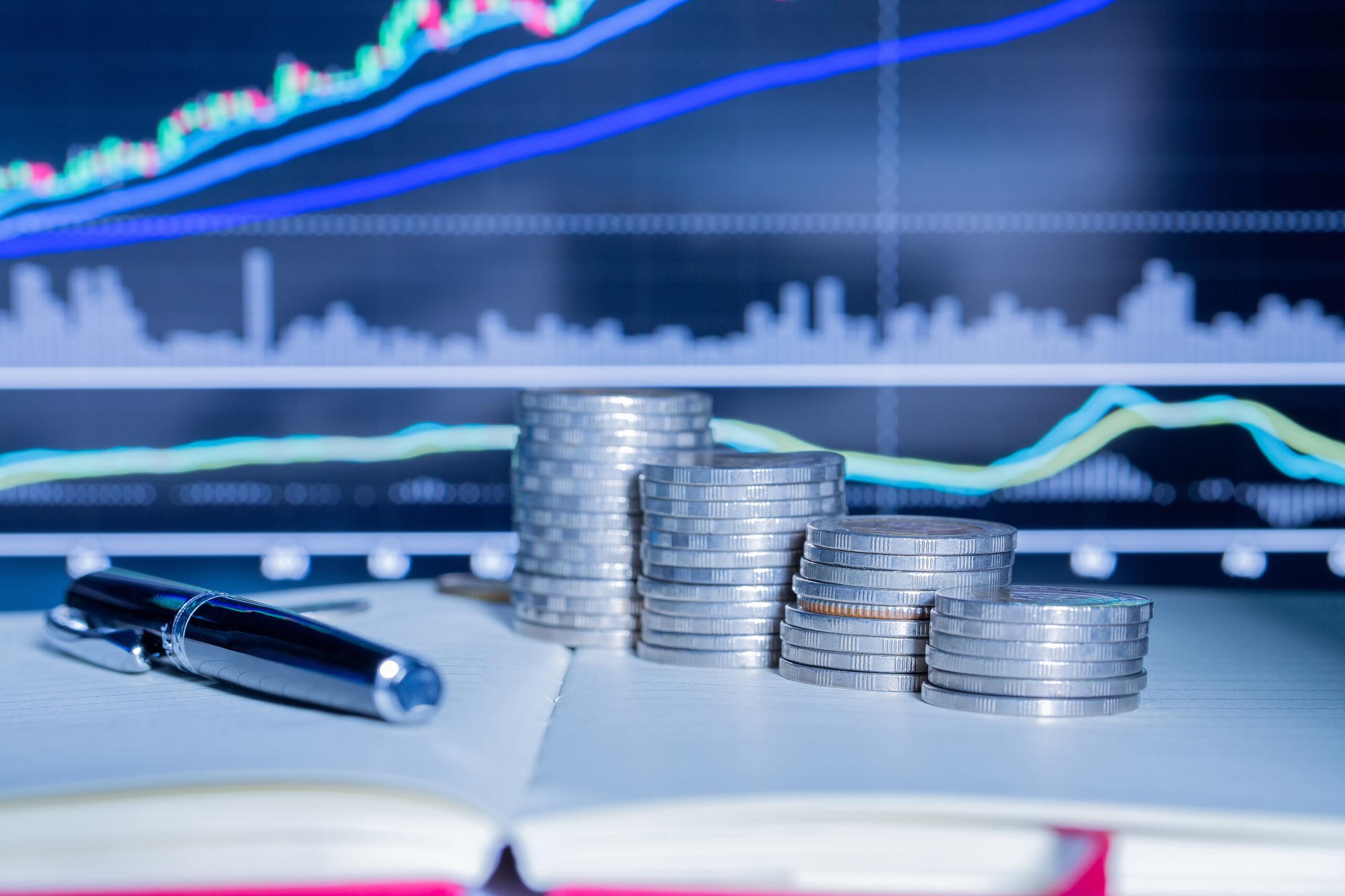 Moedas e gráfico ao fundo - melhores corretoras 2020