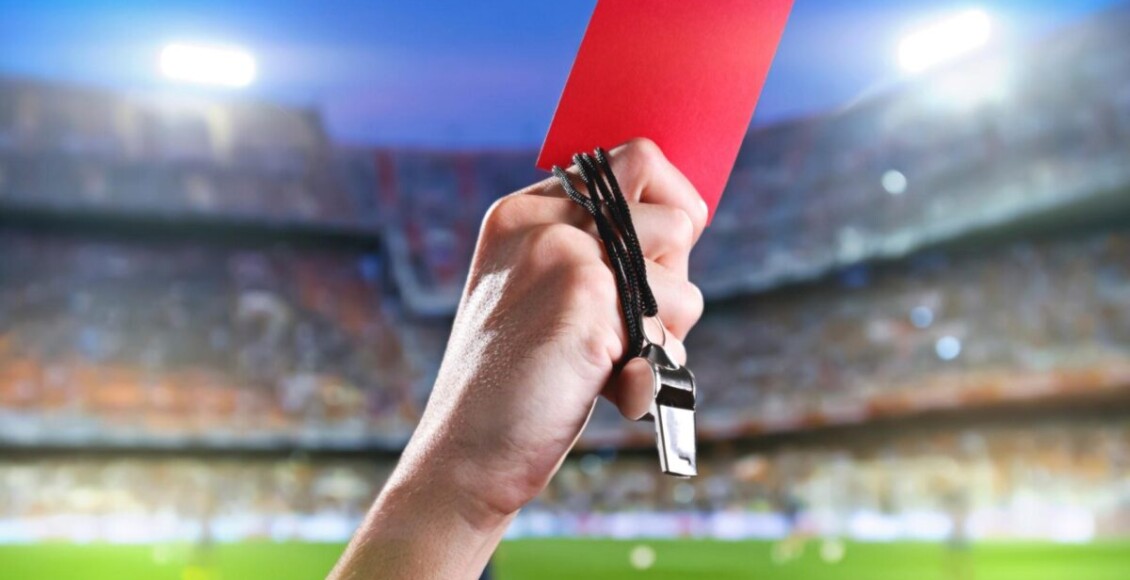 "Pra cego ver": na foto ilustrativa temos um foto não-verbal com um braço com um cartão vermelho à mão para jogadores suspensos