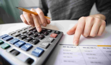 Pessoa com calculadora, lápis e papel