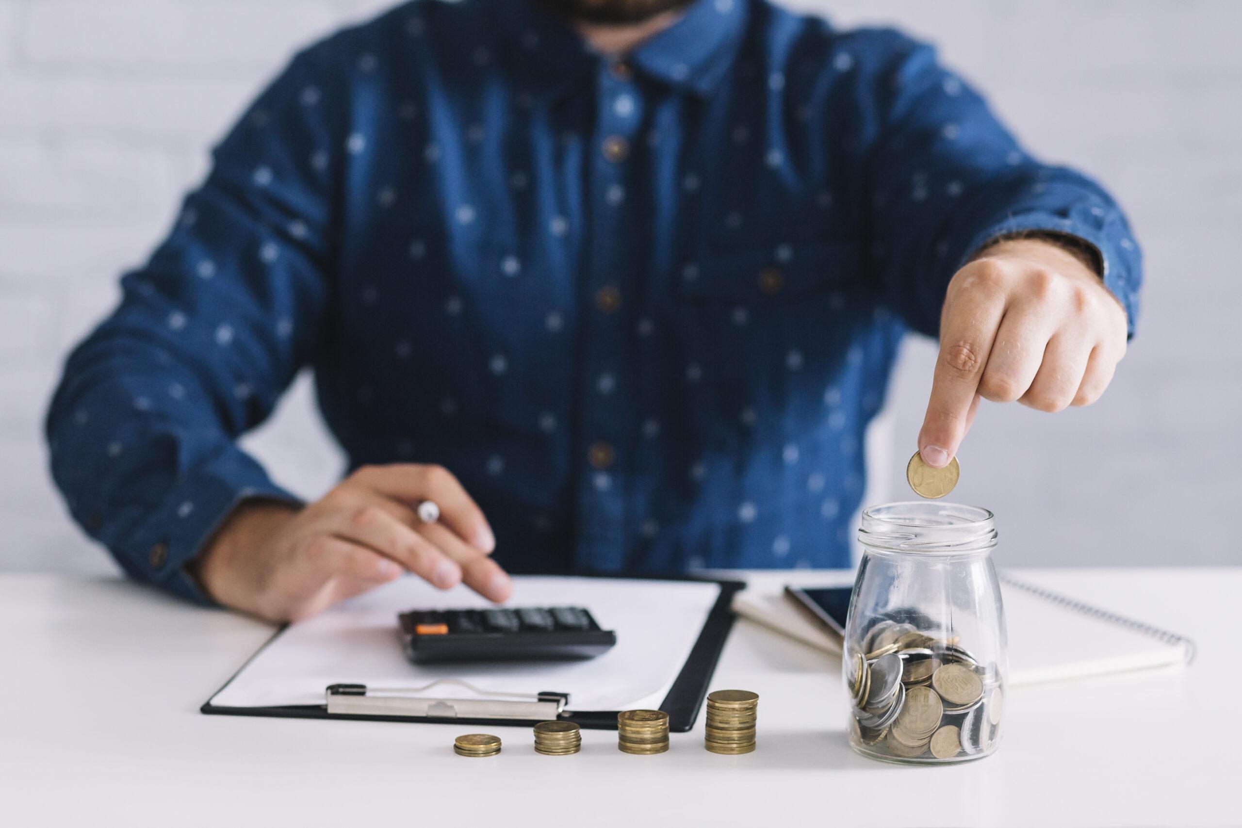 Homem calculando e inserido moedas em um pote