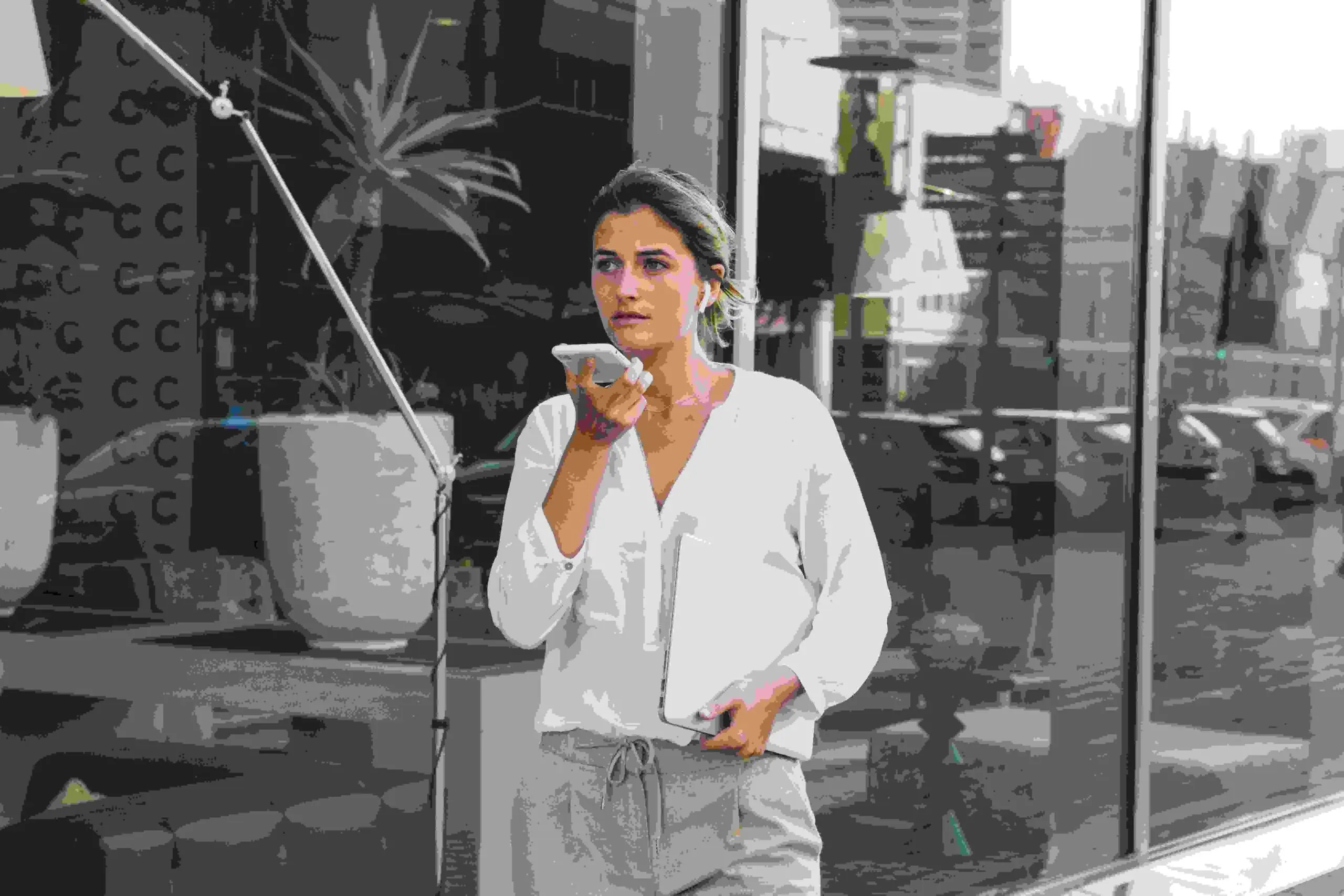 Mulher jovem em frente a edifício usando comando voz