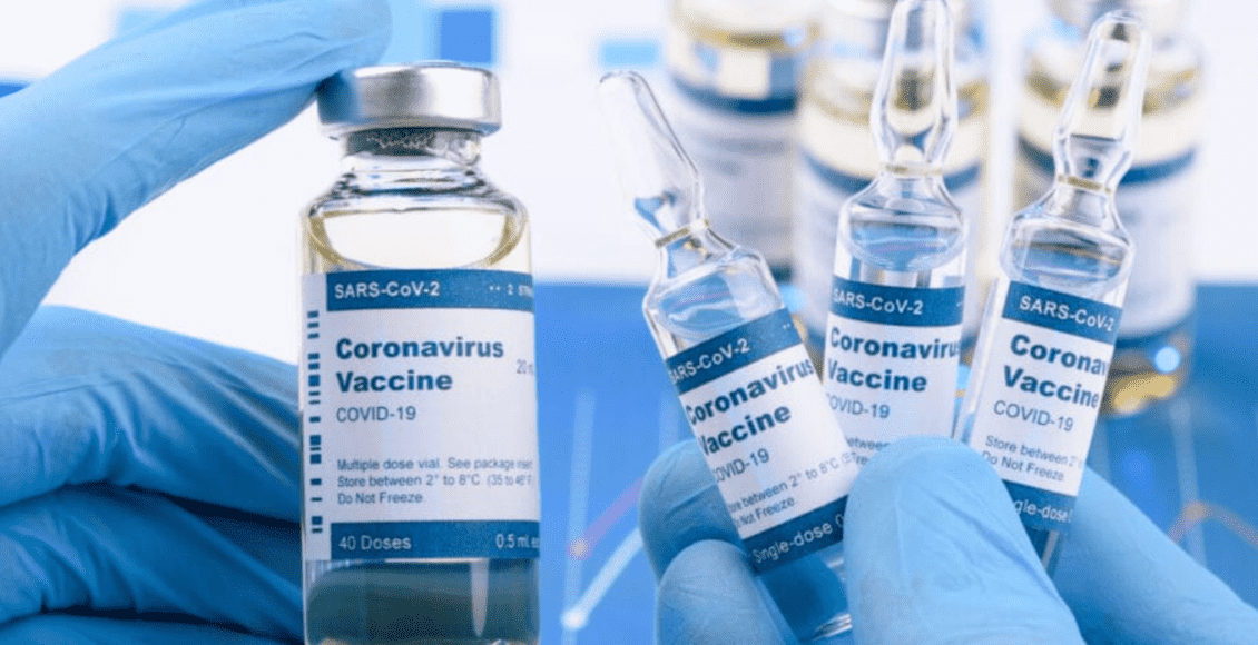 Foto mostra mãos segurando vários fracos de vacina