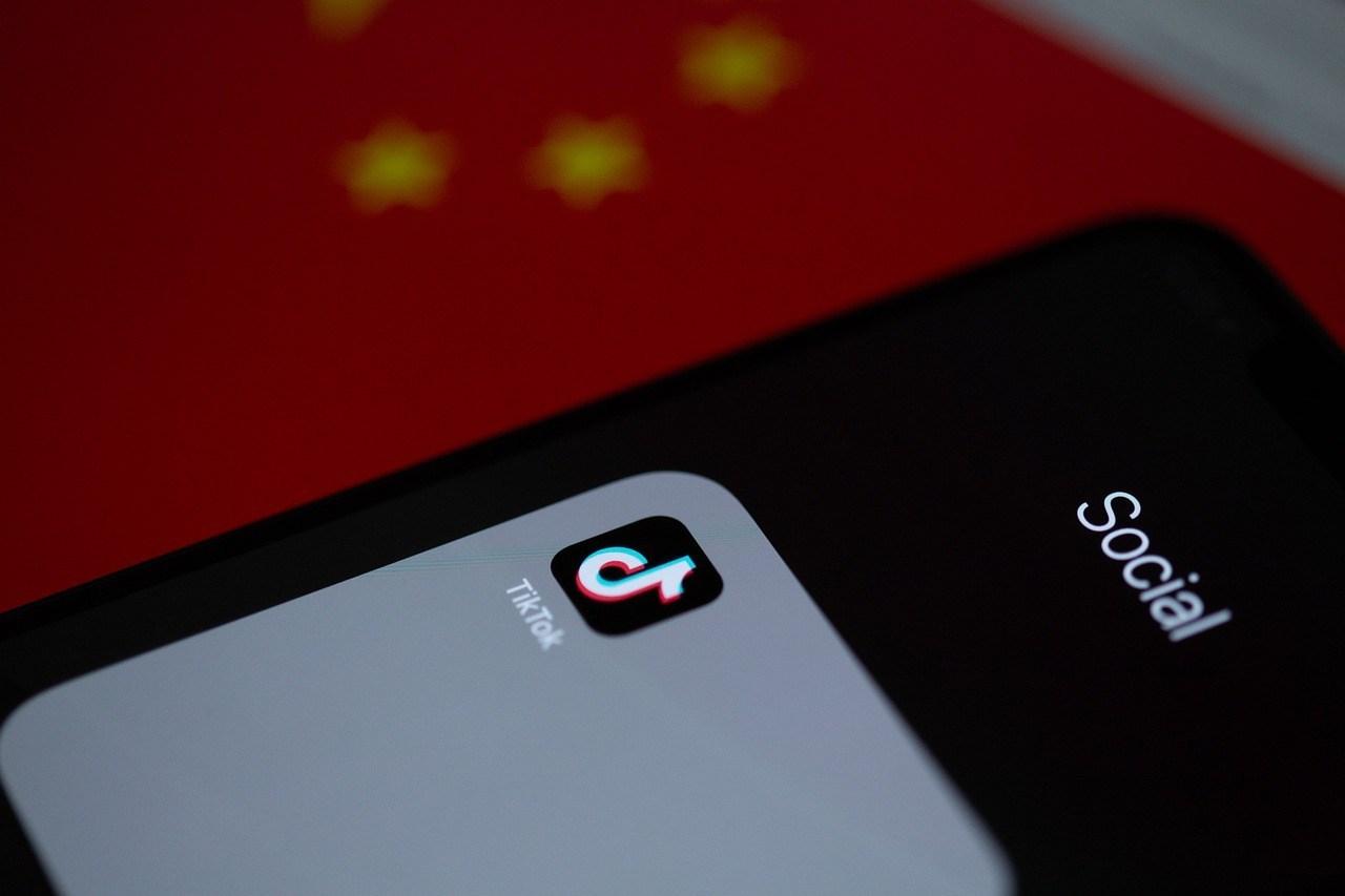 O tiktok é seguro? Celular com logo do tiktok apoiado em bandeira da china