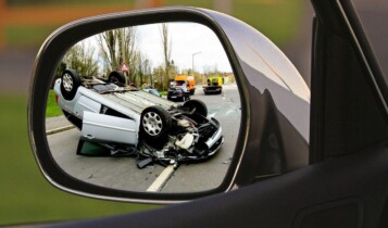 imagem refletida no retrovisor carro capotado em rodovia