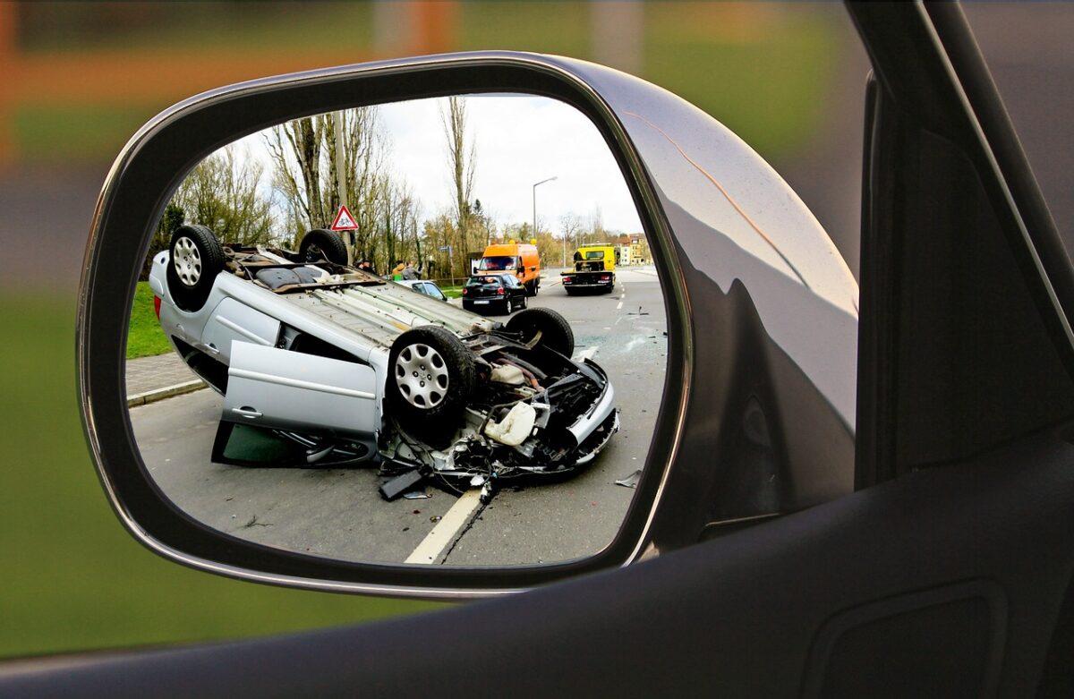 imagem refletida no retrovisor carro capotado em rodovia