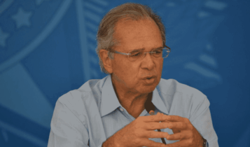 Foto mostra Paulo Guedes falando em um microfone. imposto digital