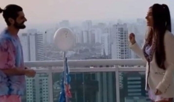 Alok e Romana Novais frente a frente estourando o balão do chá revelação