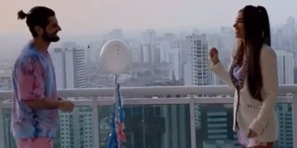 Alok e Romana Novais frente a frente estourando o balão do chá revelação