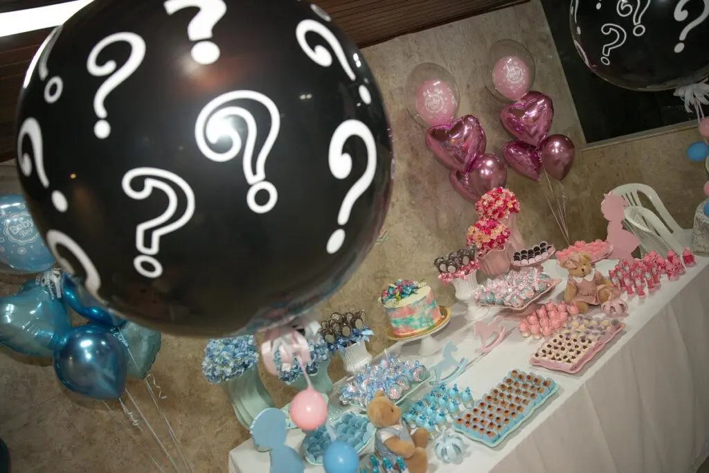 Detalhe de balão preto com pontos de interrogação que será estourado e mostrará o sexo da criança nas cores azul ou rosa