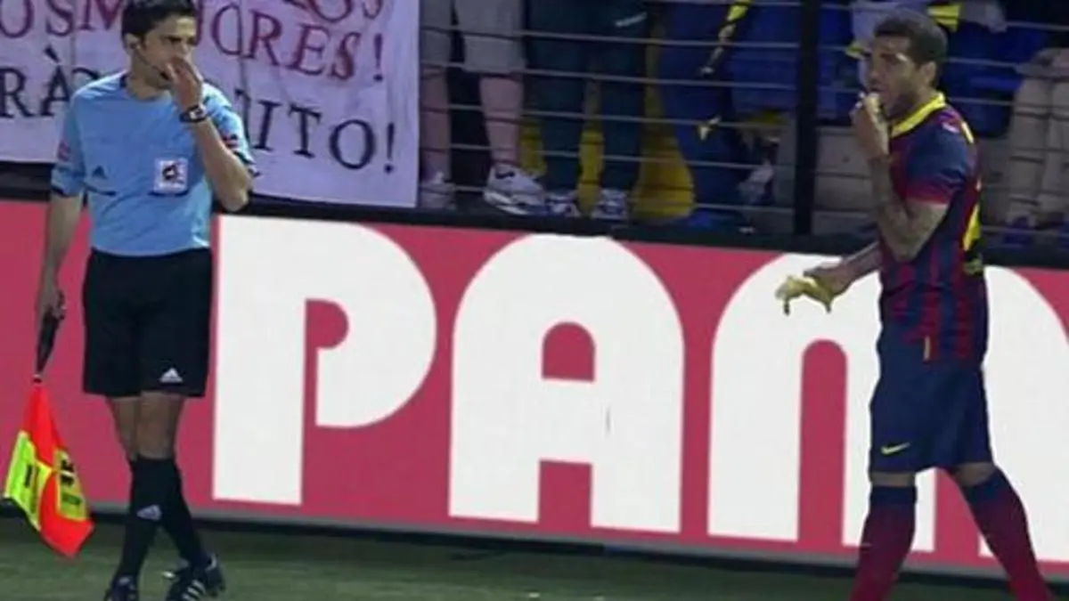 Daniel Alves come banana jogada em campo