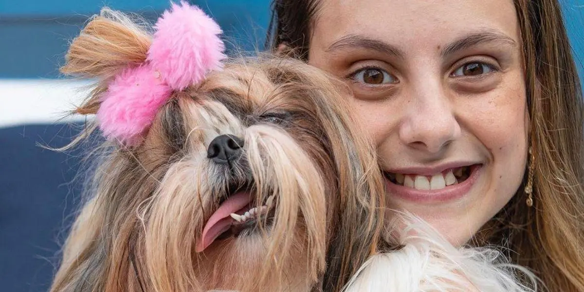 Isabella Savaget sorrindo olhando para frente com a sua cachorrinha Bellinha no colo - marcas que apostam na diversidade