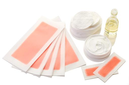 Pink waxing strips, cream and body oil isolated on white background depilação caseira