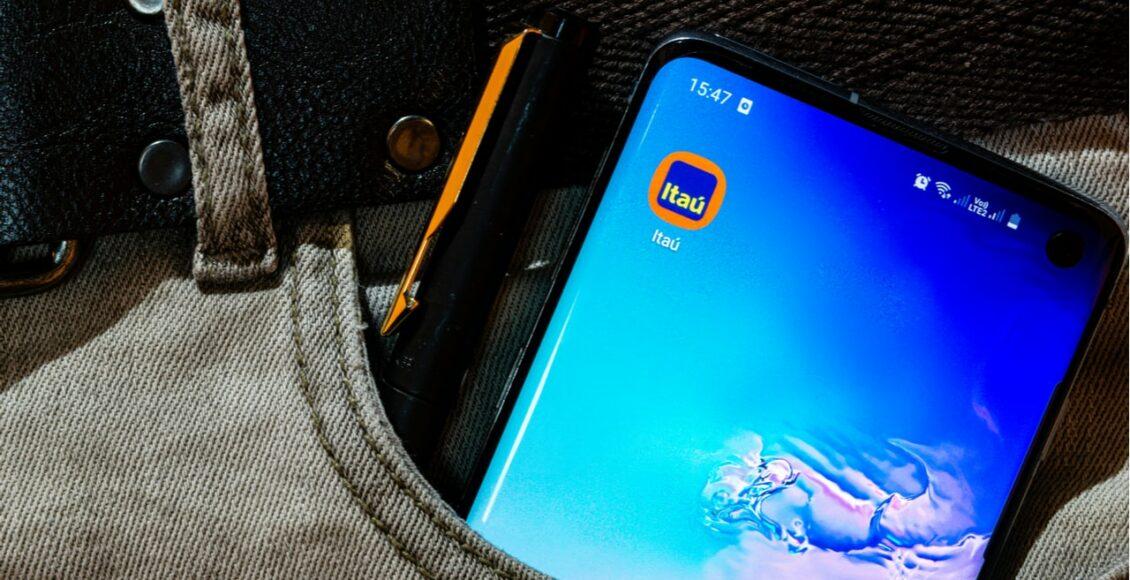 um celular com o aplicativo Itaú no bolso da calça de um homem