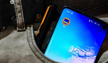 um celular com o aplicativo Itaú no bolso da calça de um homem