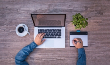 imagem de cima mostrando uma mesa com notebook e um teclado virtual para desenho