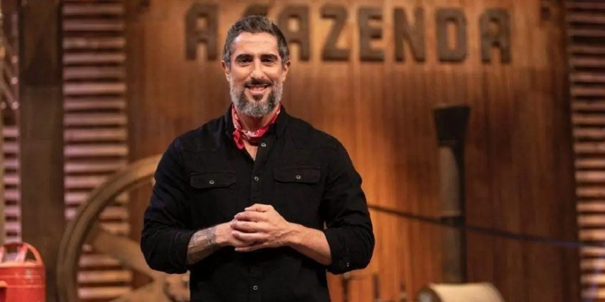 Marcos Mion posado entrelaçando as mãos no palco de "A Fazenda"