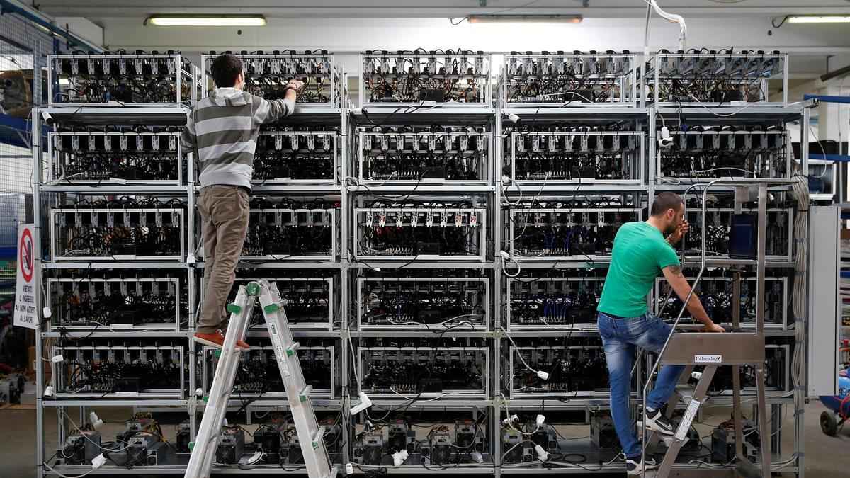 técnicos fazendo manutenção em uma mineradora industrial para minerar bitcoin