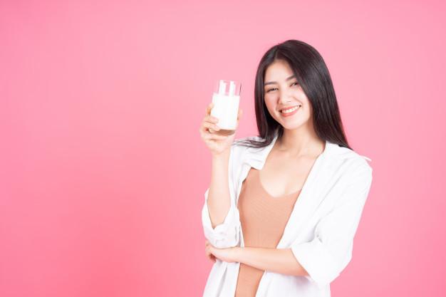 Mulher de beleza asiatica linda garota se sentir feliz bebendo leite para uma boa saude de manha no fundo rosa 1150 10222