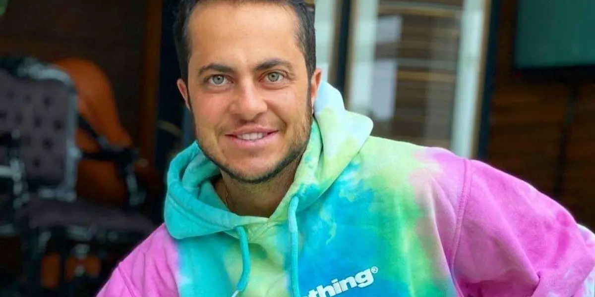 Thammy Miranda olhando para frente sorrindo com moletom colorido