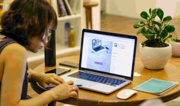 Mulher fazendo anotações com o notebook a frente