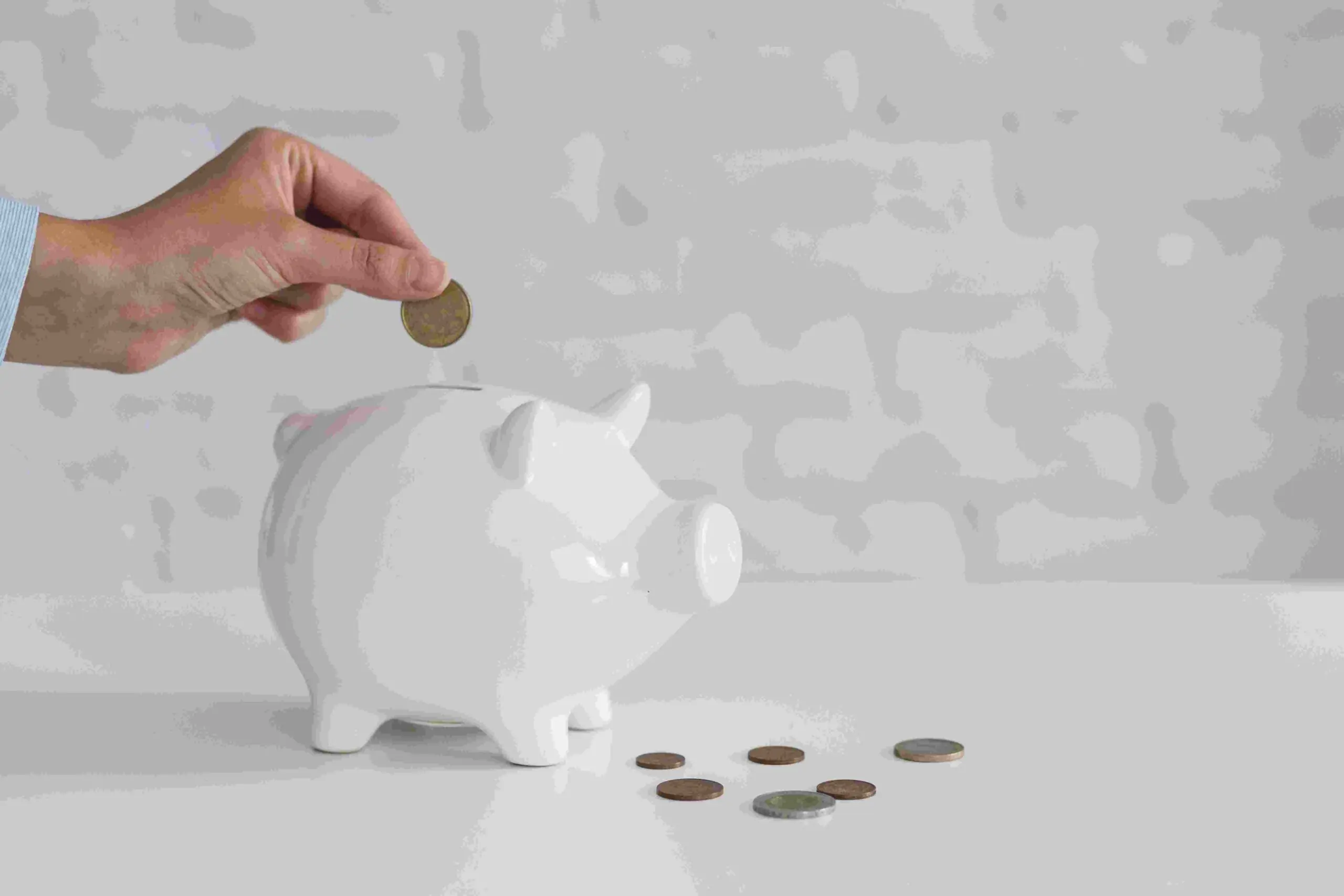 Mulher colocando dinheiro em cofrinho