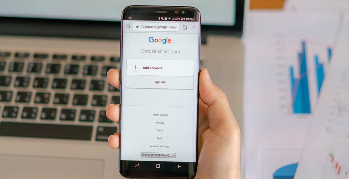 Homem segurando celular com conta Google