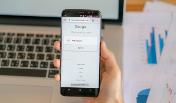 Homem segurando celular com conta Google