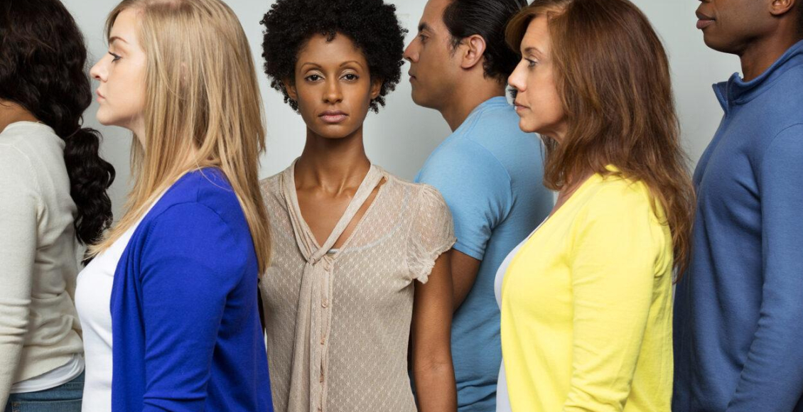 mulher negra de frente enquanto brancos e homens estão de perfil