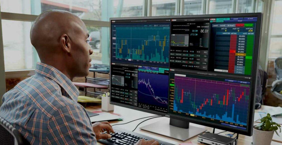 trader olhando monitores com gráficos e cotações para arbitragem