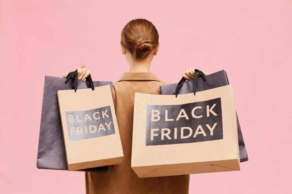 mulher de costas com sacolas escritas Black Friday