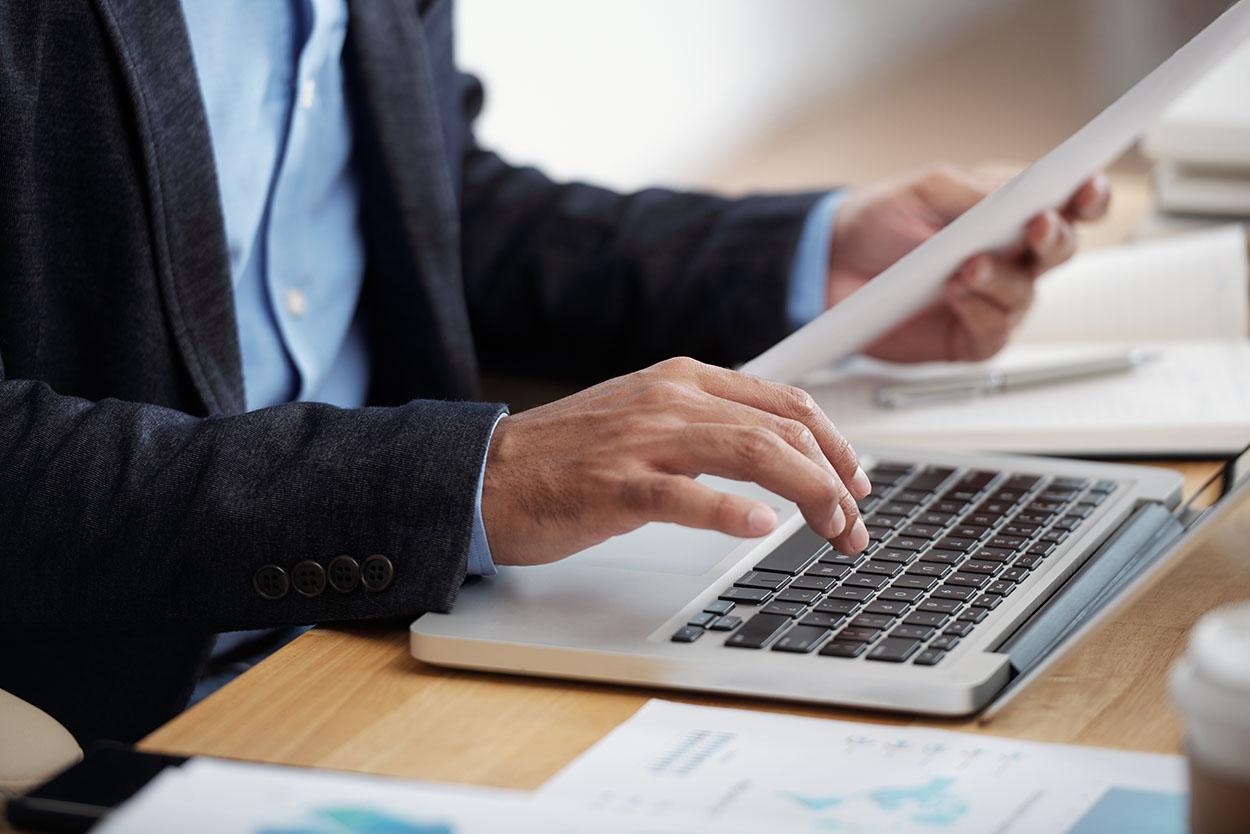 Homem digitando no notebook realizando a declaração do MEI