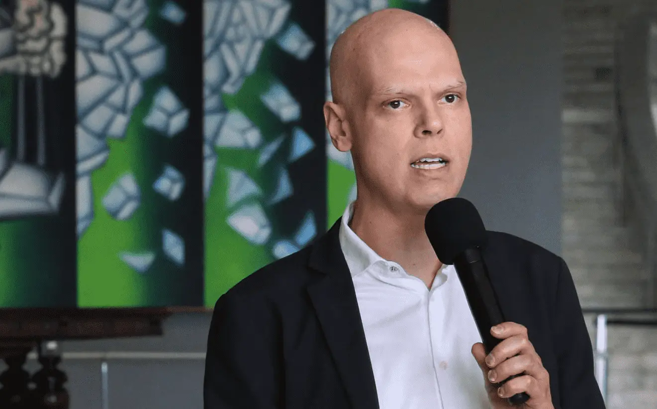 Foto mostra Bruno Covas falando em um microfone. 