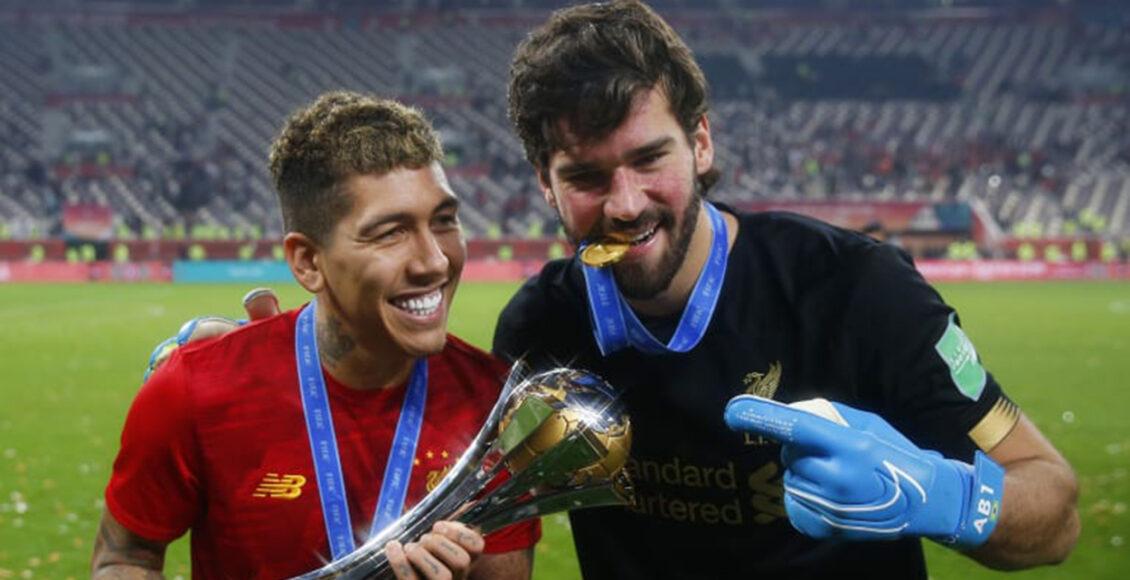 Firmino e Alisson seguram o troféu do Mundial de Clubes conquistado pelo Liverpool; edição de 2020 está incerta