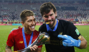 Firmino e Alisson seguram o troféu do Mundial de Clubes conquistado pelo Liverpool; edição de 2020 está incerta